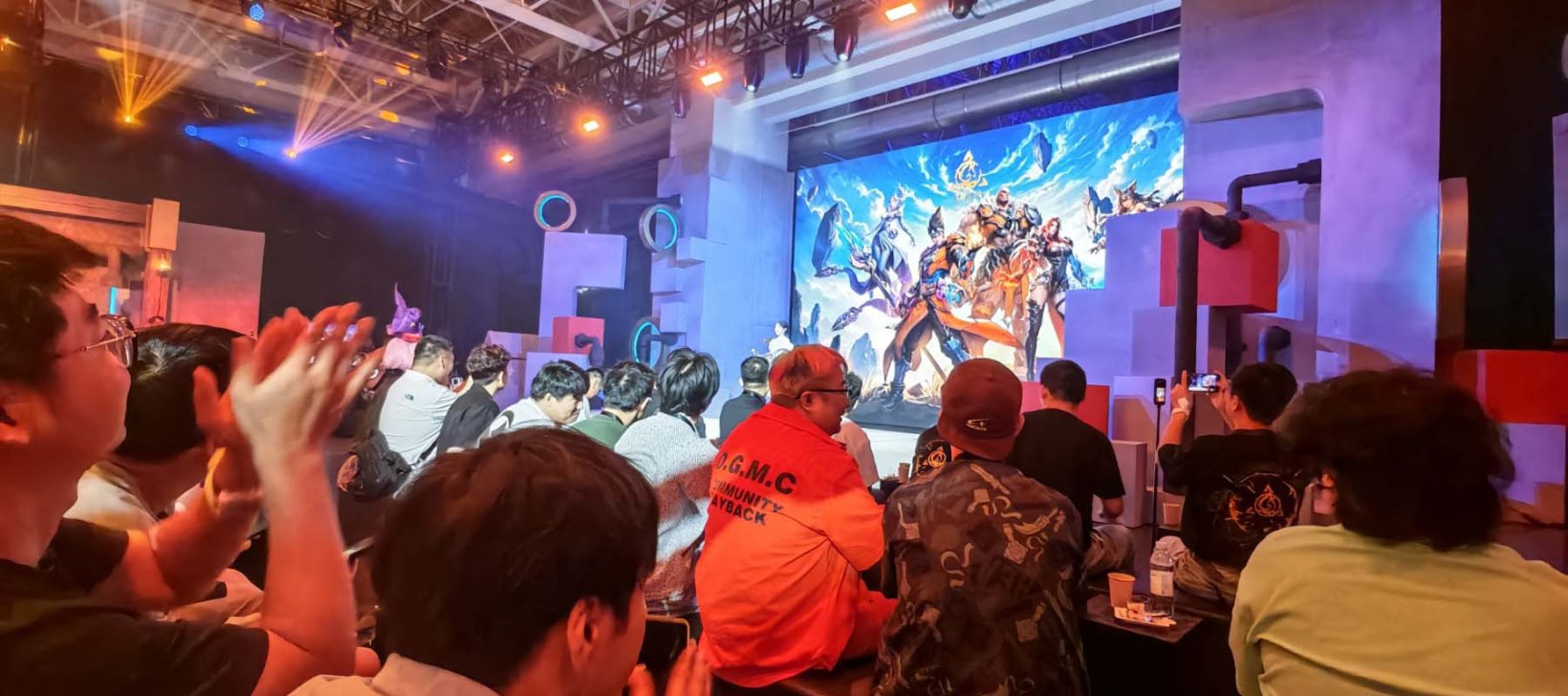 a crowd watching a screen on stage about torchlight infinite