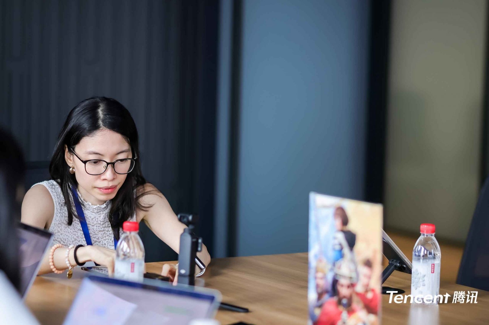 woman with glasses sitting at a desk in a conference room prepping for an interview