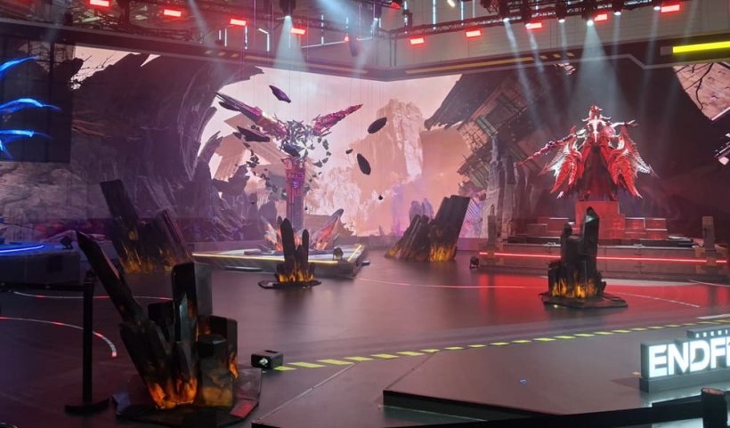 A booth on a convention floor showing fractal, miner-like creatures depicted in statue form.