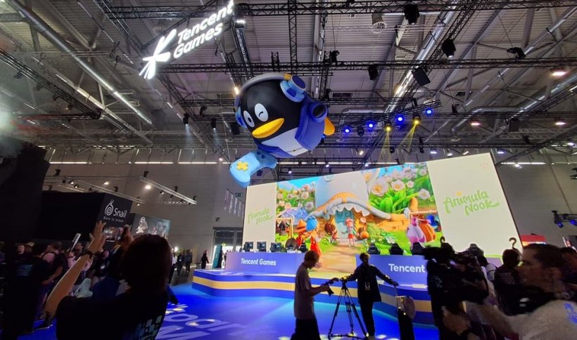 A depiction of the enormous penguin-shaped mascot of Tencent towering over a convention booth.