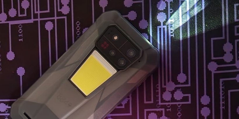 Tank 4 Pro rugged phone on black and purple mousepad with projector light shining