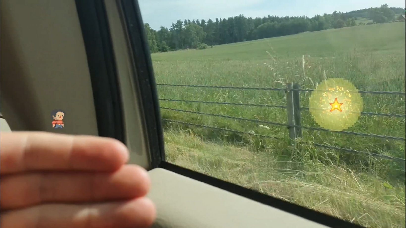A man is holding out his hand, with a small pixel character stood atop it. In the background we can see he's on a train, and a star is across the photograph out of reach of the character.