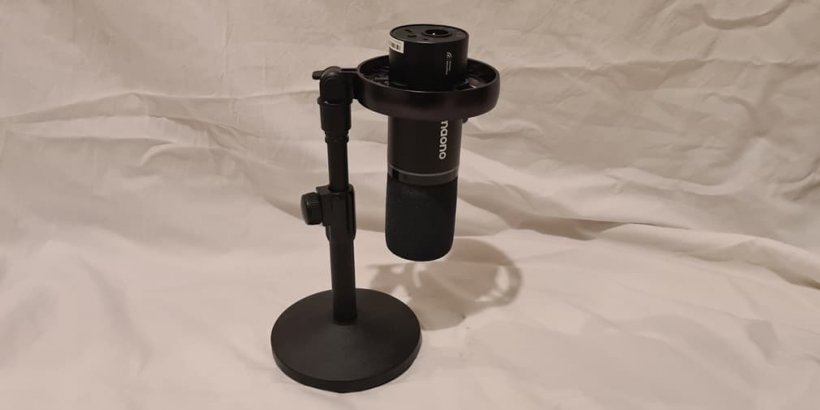 A picture of a black, suspended microphone tilted over on a white background