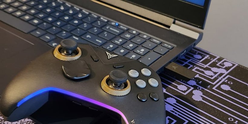 Vader 5 Pro resting on a laptop keyboard with included dongle plugged into the laptop