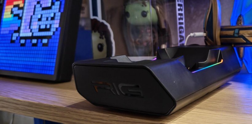 a charging base with RGB lights on a table with accessories in the background