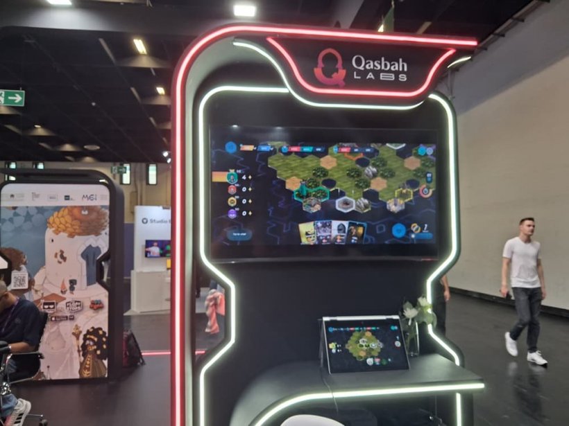 An image of a booth featuring gameplay of a hex-based strategy game called Rivaldom on a small screen.
