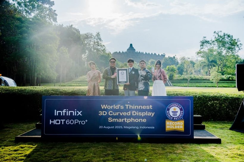 A picture of a group of people holding a plaque in front of a temple.