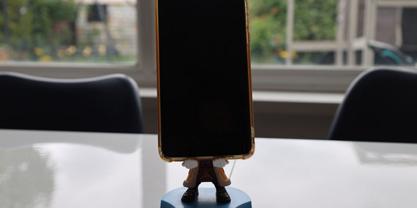 The One Piece Buggy Cable Guy Holdems Mini holding a phone